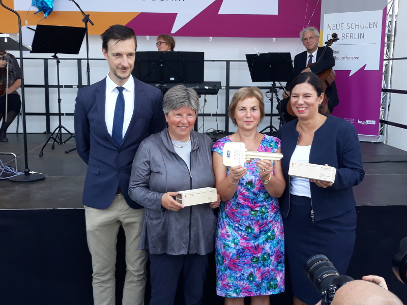 Gordon Lemm, Senatorin Katrin Lompscher, Schulleiterin Sibylle Fricke und Senatorin Sandra Scheeres mit dem Schlüssel und zwei Mini-Holz-Modulen