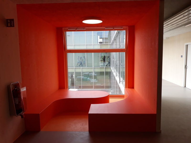 Rote Sitznische an einem Flur mit Ausblick auf das Schulgebäude der ISS Mahlsdorf