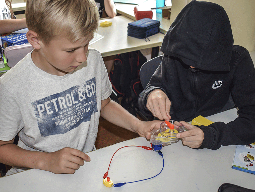 Zwei Schüler bauen einen experimentellen Generator auf
