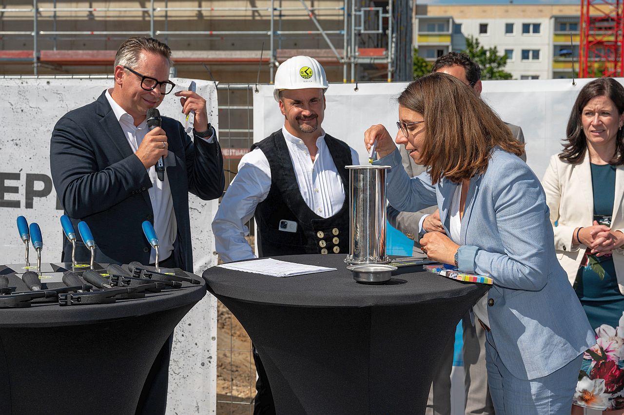 Grundsteinlegung für das Erich-Kästner-Gymnasium - Bezirksbürgermeisterin Nadja Zivkovic befüllt die Zeitkapsel