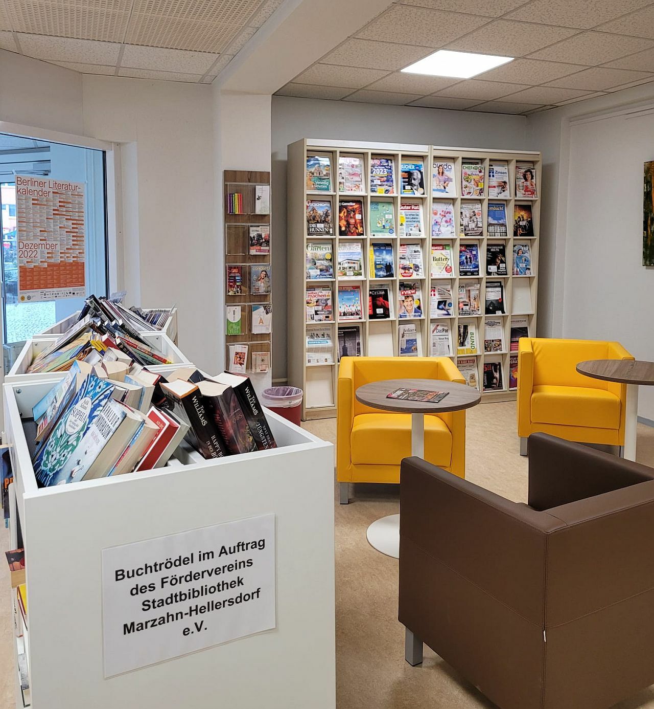Foyer und Zeitschriften-Regal mit bunten Sesseln und Büchertrödel