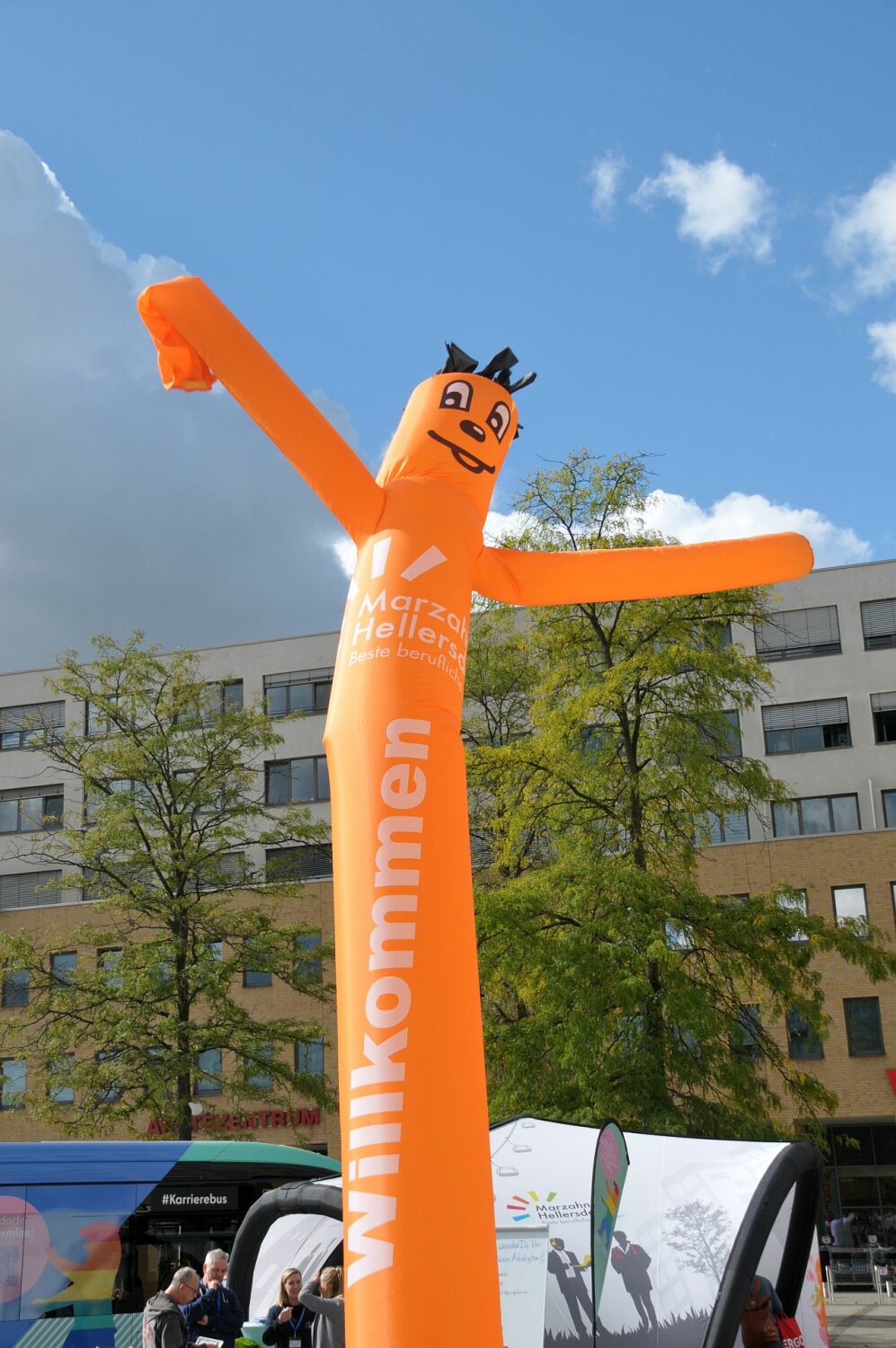 #MachsMitUns - Mobile Berufsberatung des Bezirksamts Marzahn-Hellersdorf auf dem Alice-Salomon-Platz - Orangener "Airdancer" mit dem Bezirkslogo und dem Schriftzug "Willkommen" auf dem Alice-Salomon-Platz