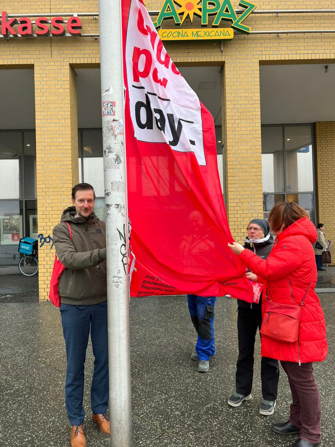 Bezirksbürgermeister Gordon Lemm hisst die Flagge zum Equal Pay Day