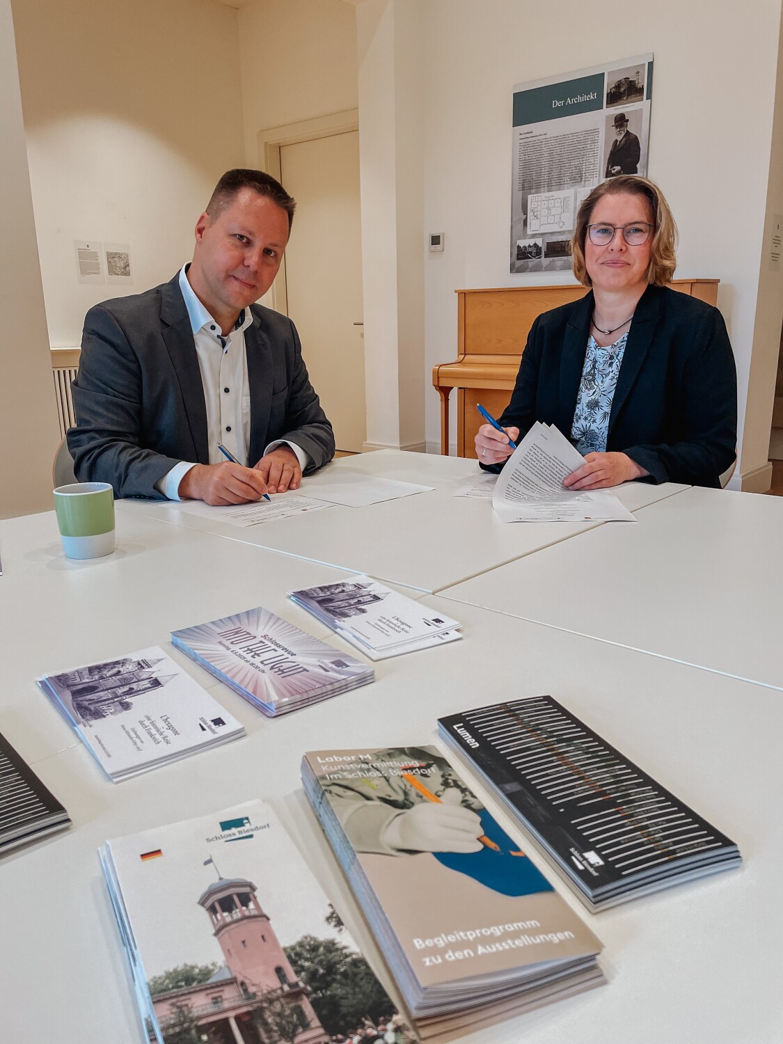 Stefan Bley, Bezirkskulturstadtrat von Marzahn-Hellersdorf und Katja Kaiser, Kulturdezernentin des Landkreises Oder-Spree unterschreiben die Kooperationsvereinbarung