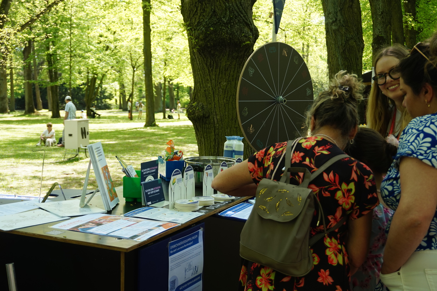 Besuchende am Stand des Raums für Beteiligung informieren sich über die Förderangebote im Bezirk.