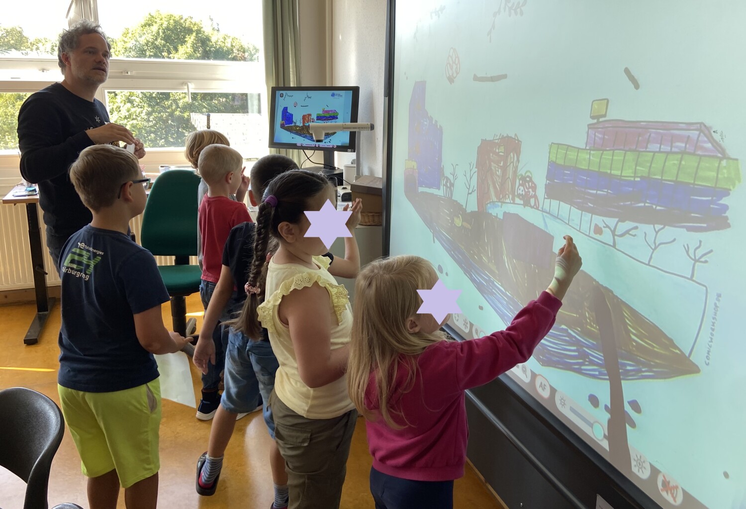 Sechs Kinder präsentieren zusammen mit Workshopleiter Steffen Hand ihre Ergebnisse auf dem Whiteboard.