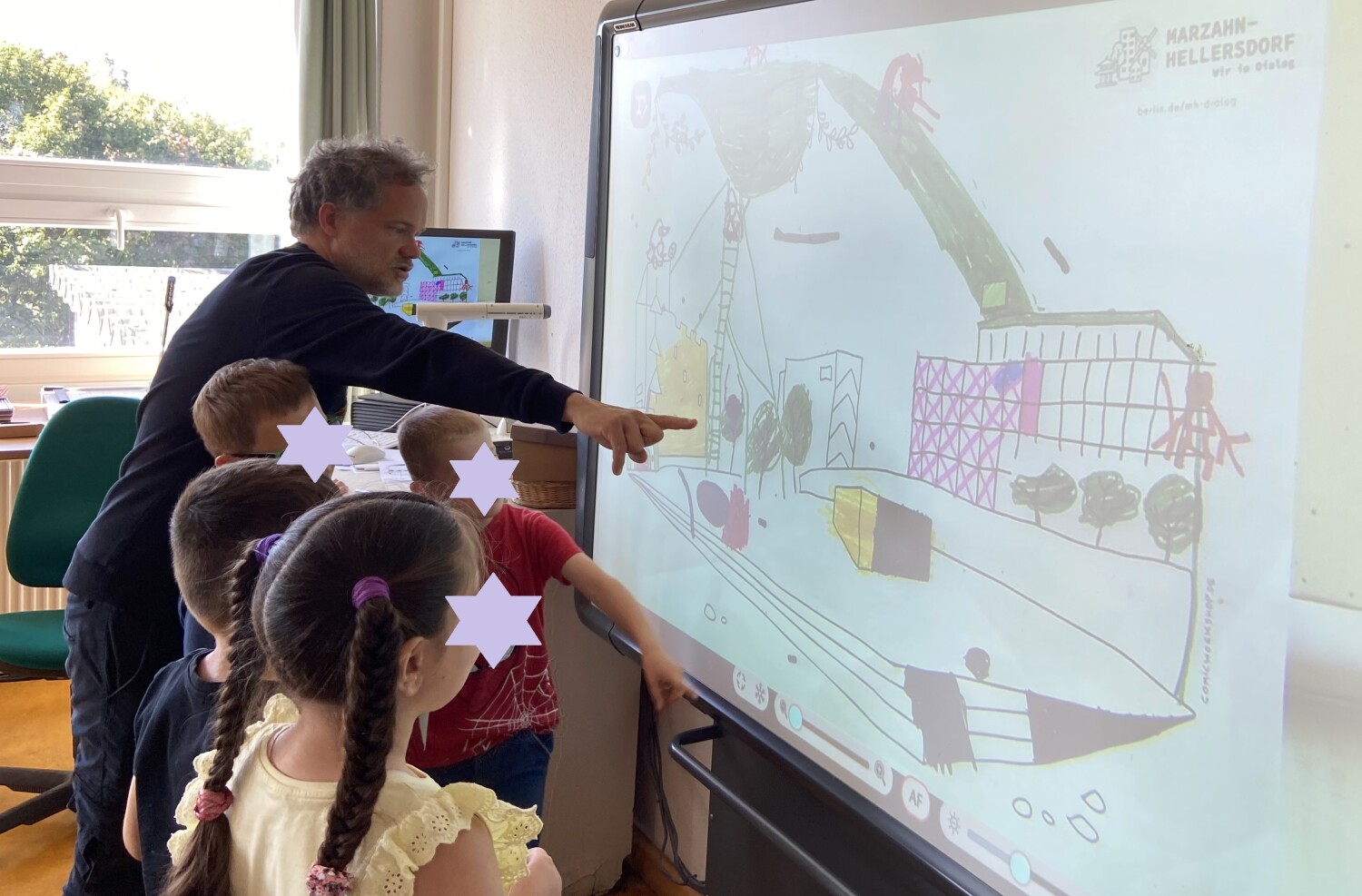 Vier Kinder präsentieren zusammen mit dem Workshopleiter Steffen Hand ihre Ergebnisse auf dem Whiteboard. Das präsentierte Bild zeigt den zu gestaltenden Platz. Eine große Rutsche ist hier sehr präsent.