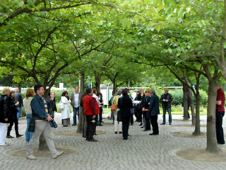 Menschengruppe unter Bäumen im Angerdorf Marzahn