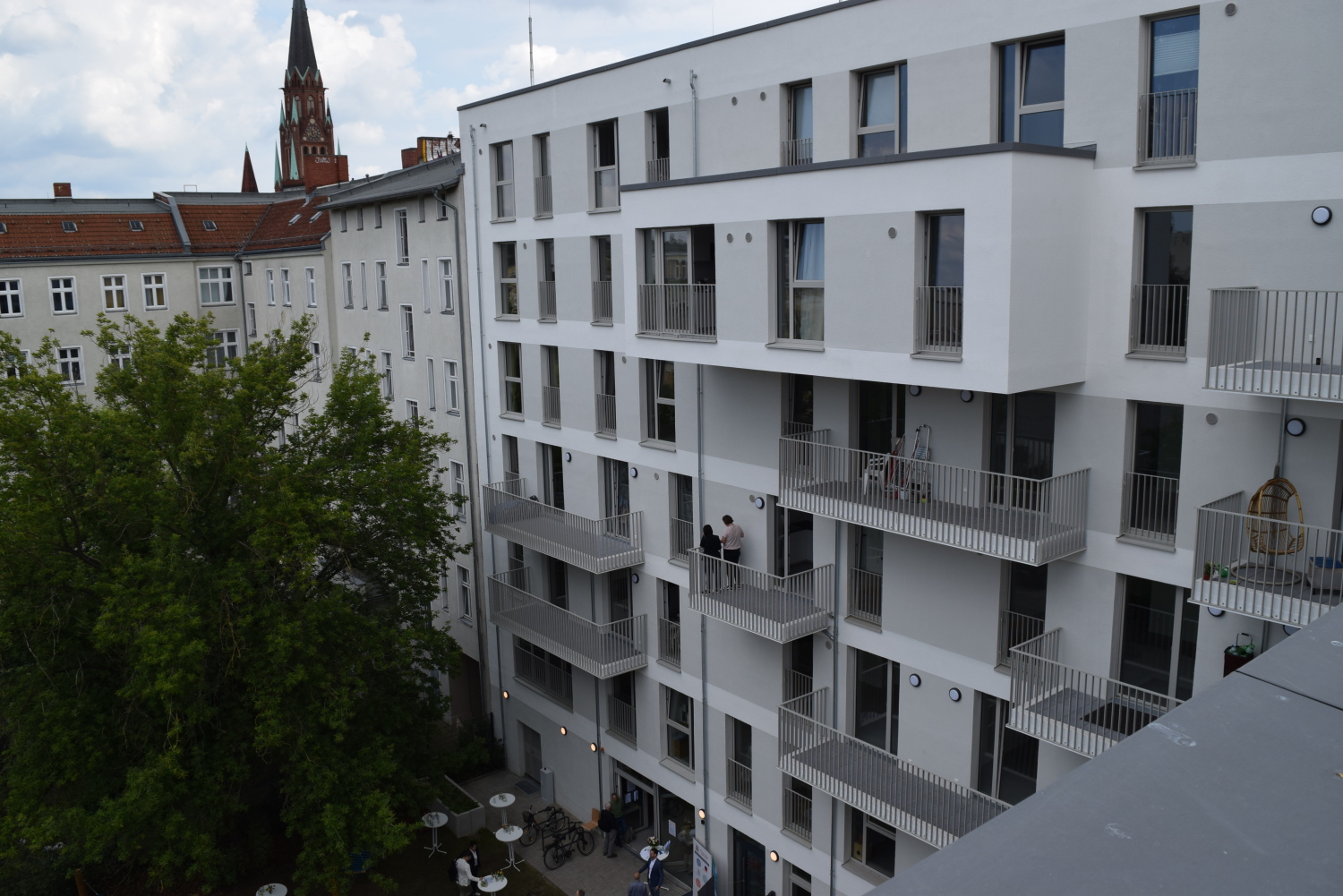Blick von der Dachterrasse in den grünen Innenhof mit Spielplatz.