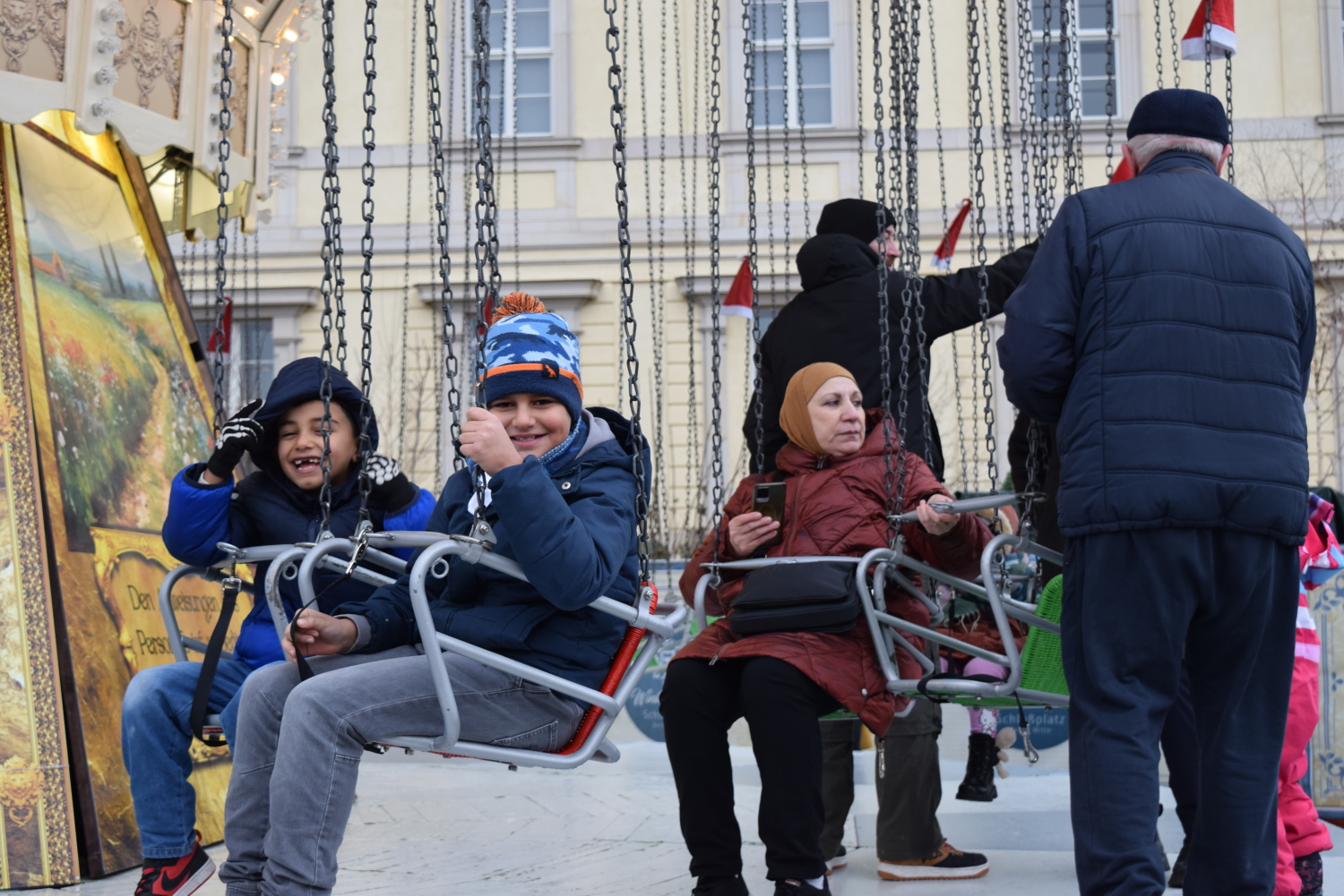 Kinder auf dem Kettenkarrussell auf dem Wintermarkt am Humboldtforum.