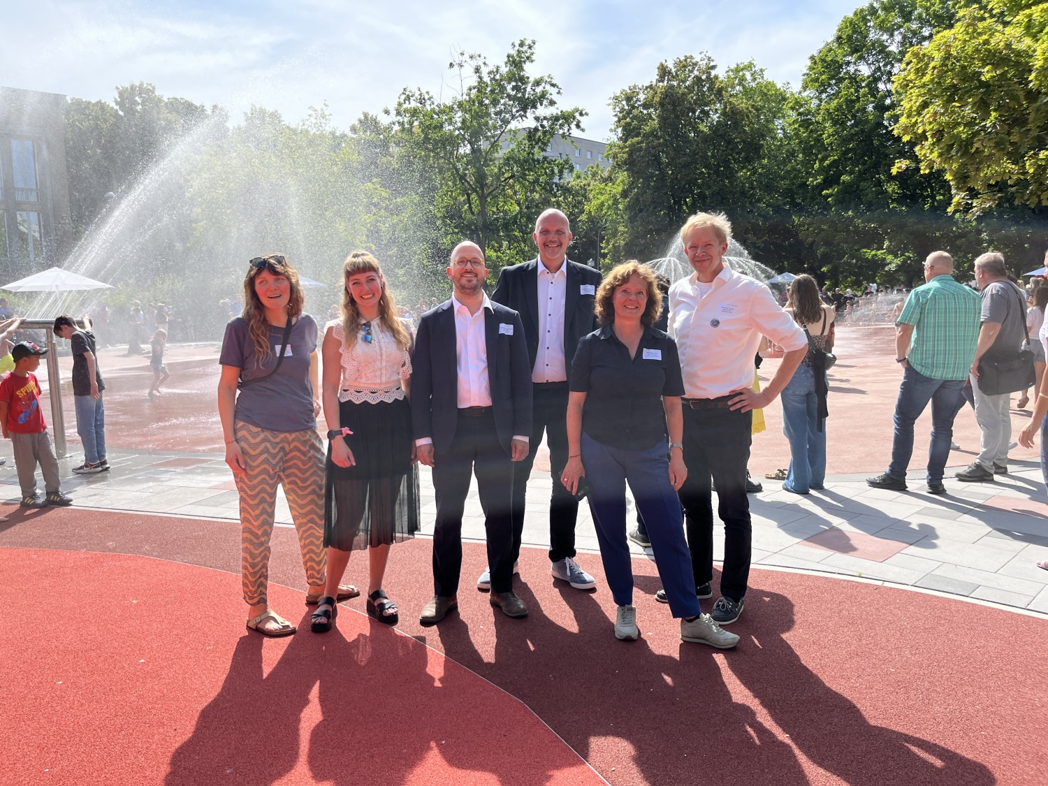 Die Bezirksstadträte Christopher Schriner (3.v.l.), Ephraim Gothe (r.) und Staatssekretär Stephan Machulik (3.v.r.) sowie Landschaftsarchitektin Martina Levin (2.v.r.) bei eröffneten am 20. Juni 2024 die Plansche an der Singerstraße.