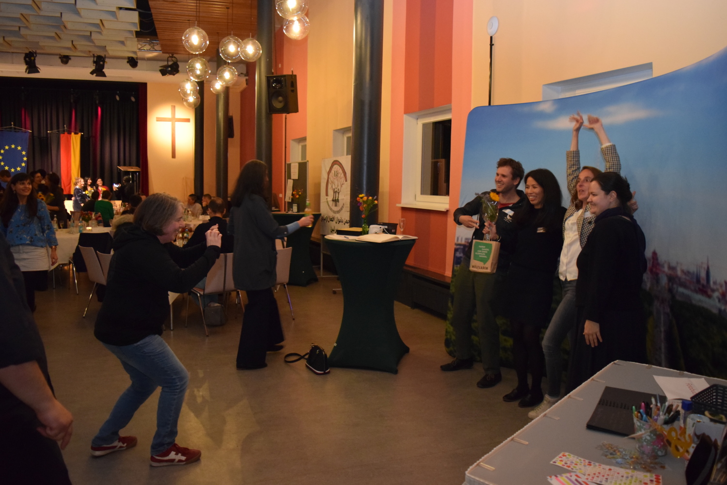 Teilnehmende der Einbürgerungsfeier in Berlin-Mitte vor einer Fotowand.