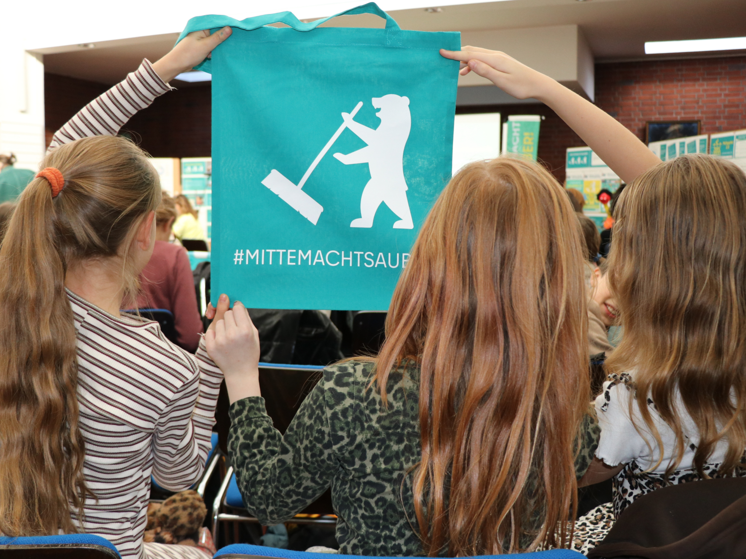 Müllgipfel drei Schülerinnen halten einen Jutebeutel der Kampagne mittemachtsauber hoch