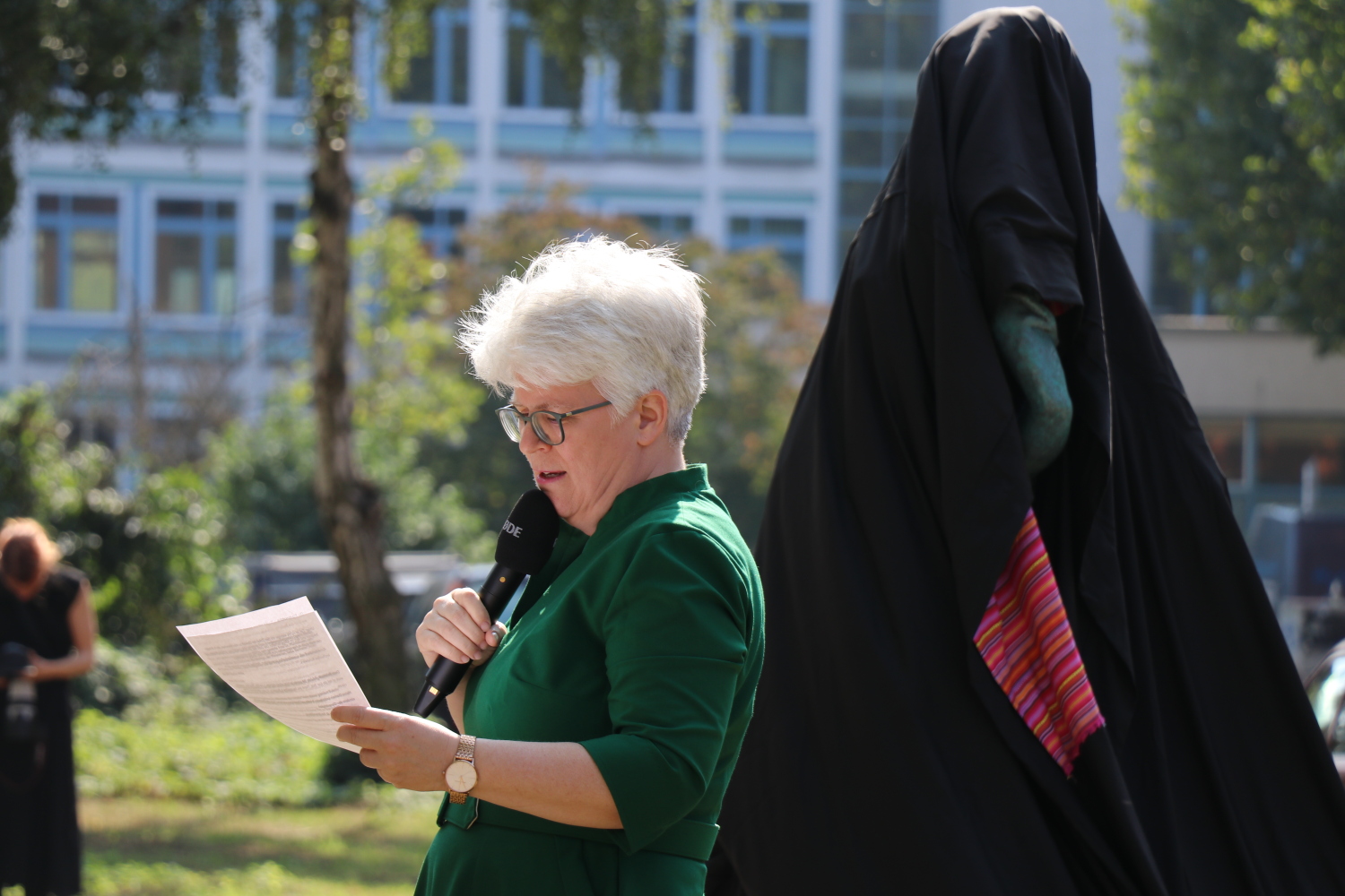 Bezirksbürgermeisterin Stefanie Remlinger spricht auf der Enthüllung der Skulptur Petrified Survivors
