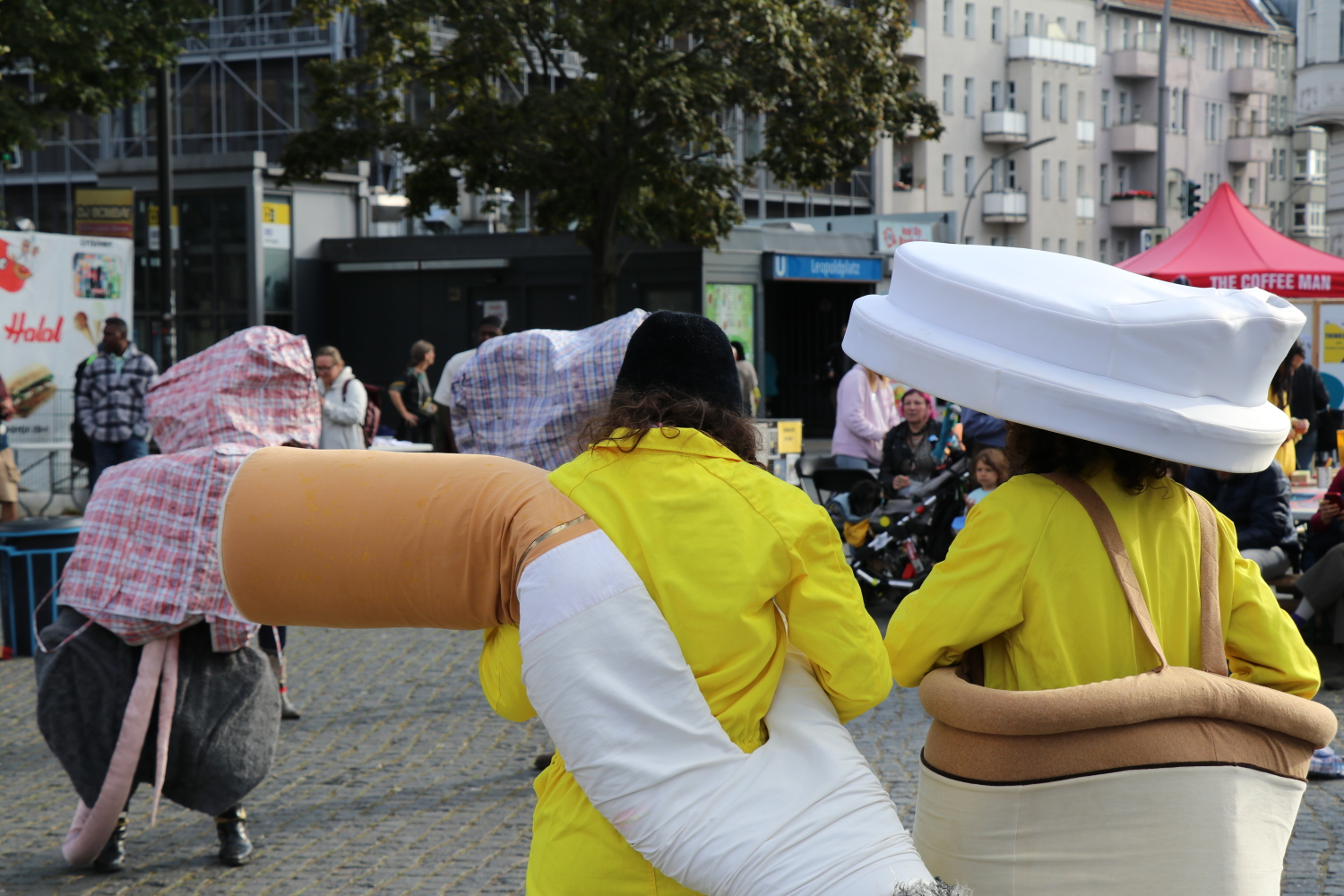 Zwei Personen, als Zigarettenkippe und To-Go-Becher verkleidet
