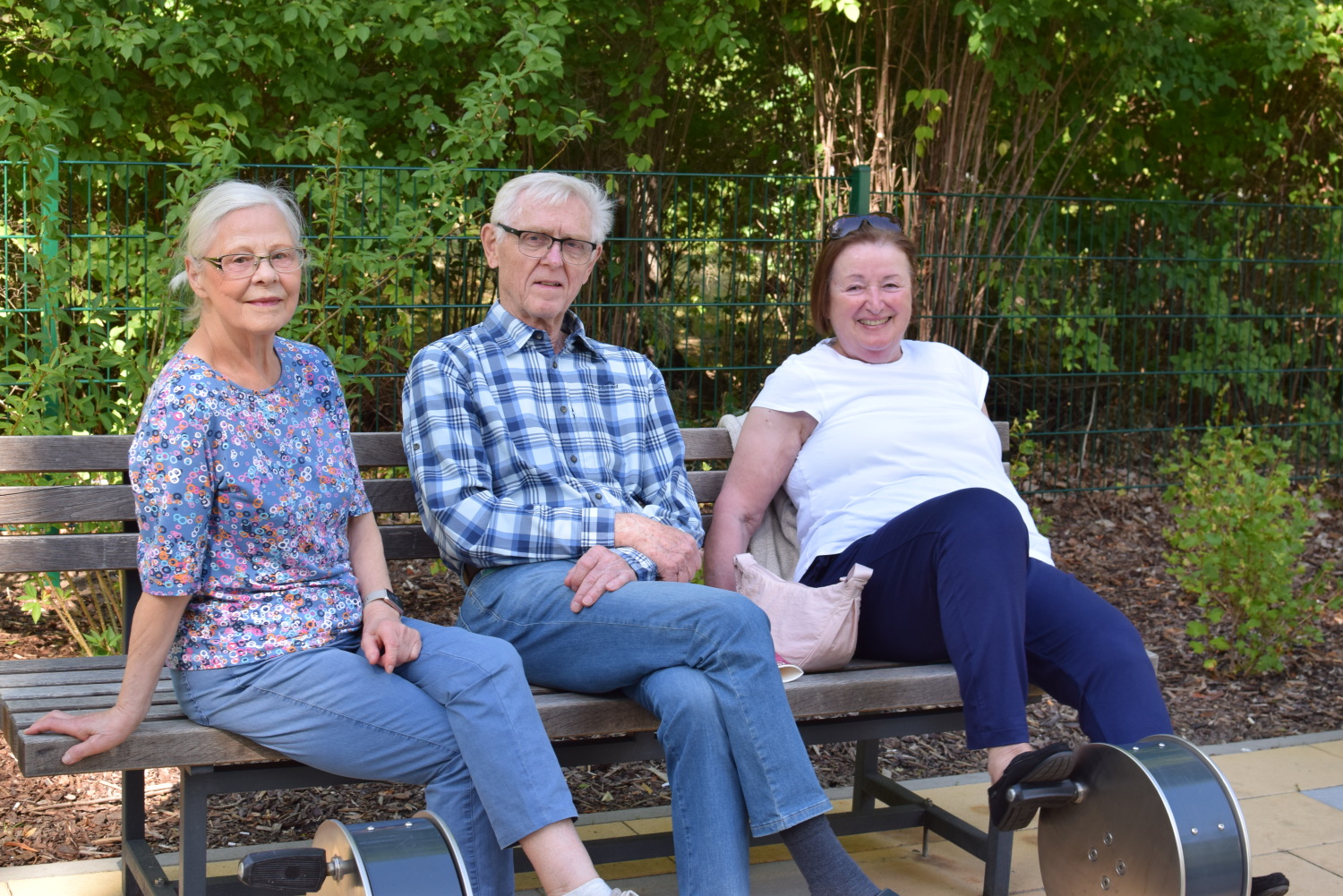 Drei Senior*innen an einem Bewegungsgerät auf dem Spielplatz an der Mollstraße 8-11.