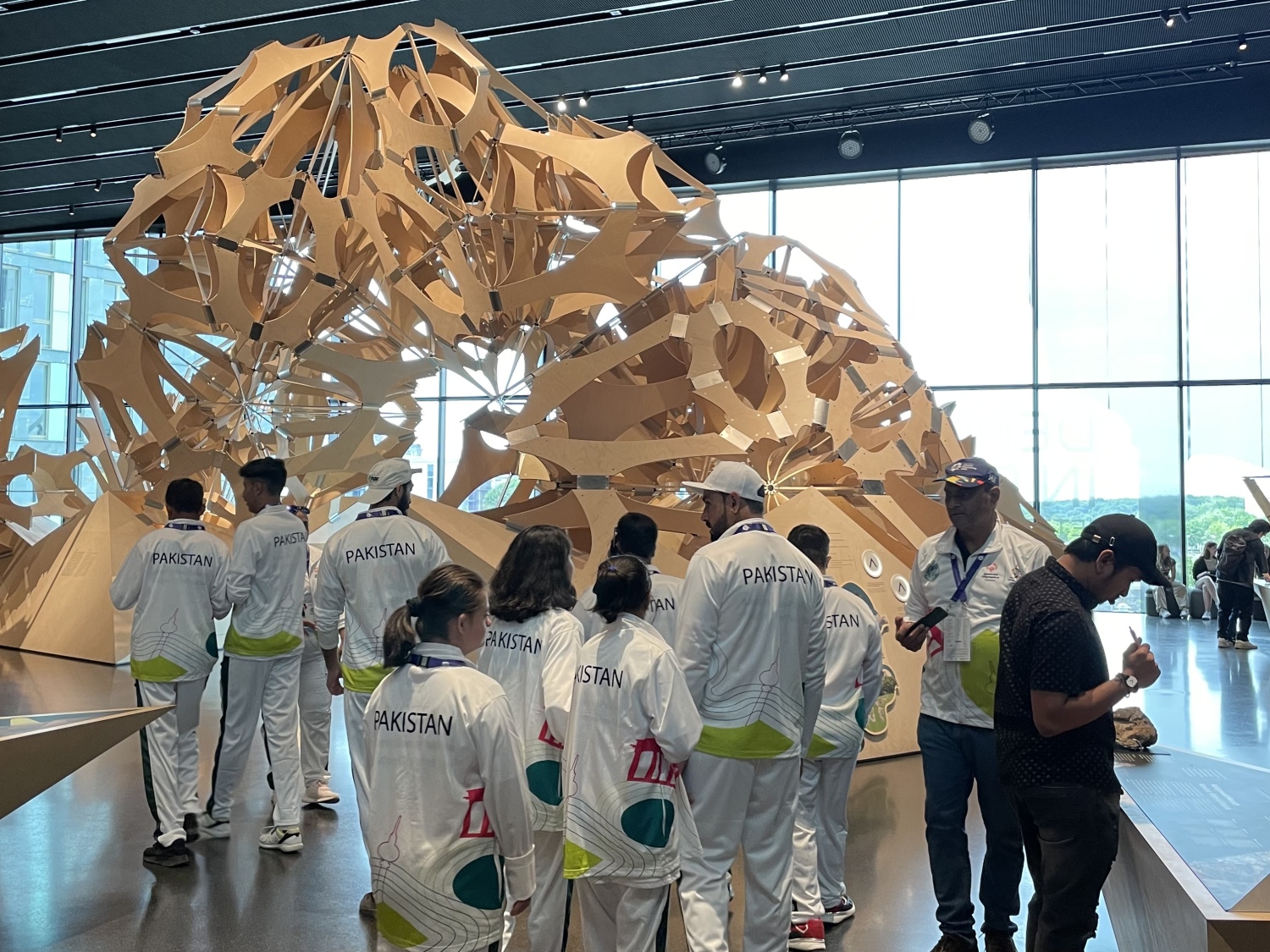 Pakistanische Sportler*innen im Futurium vor einer großen Skulptur