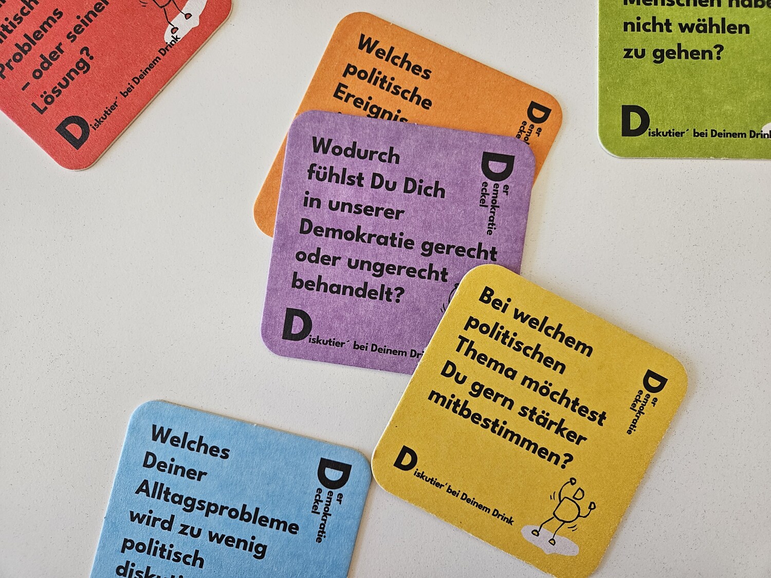 Demokratiedeckel z.B. mit Aufschrift "Wodurch fühlst Du Dich in unserer Demokratie gerecht oder ungerecht behandelt"