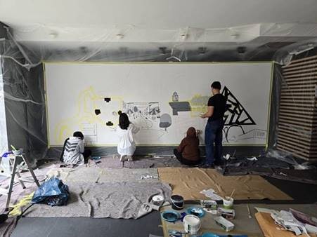 Der Berliner Graffiti Künstler Sebastian Grap hat mit den Schüler:innen der Gesamtschule Janusz Korczak an zwei Großformaten, Collagen von Bottroper Motiven erarbeitet und besprüht. Im zukünftigen Ladenlokal wurde das dritte Projekt von den Schülerinnen und Schülern an die Wand gebracht – Motive der Freizeit, der Stadtgeschichte und der Zukunft ihrer Stadt.