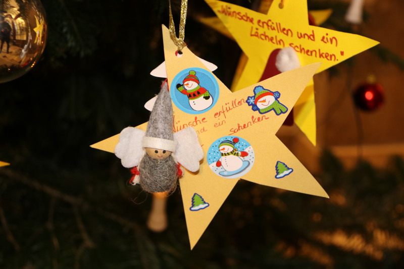 Kinder aus Pflege- und Betreuungseinrichtungen haben ihre Weihnachtswünswche in Sternform gebastelt und hängen diese jetzt an denNeuköllner Wunschbaum im Rathaus.