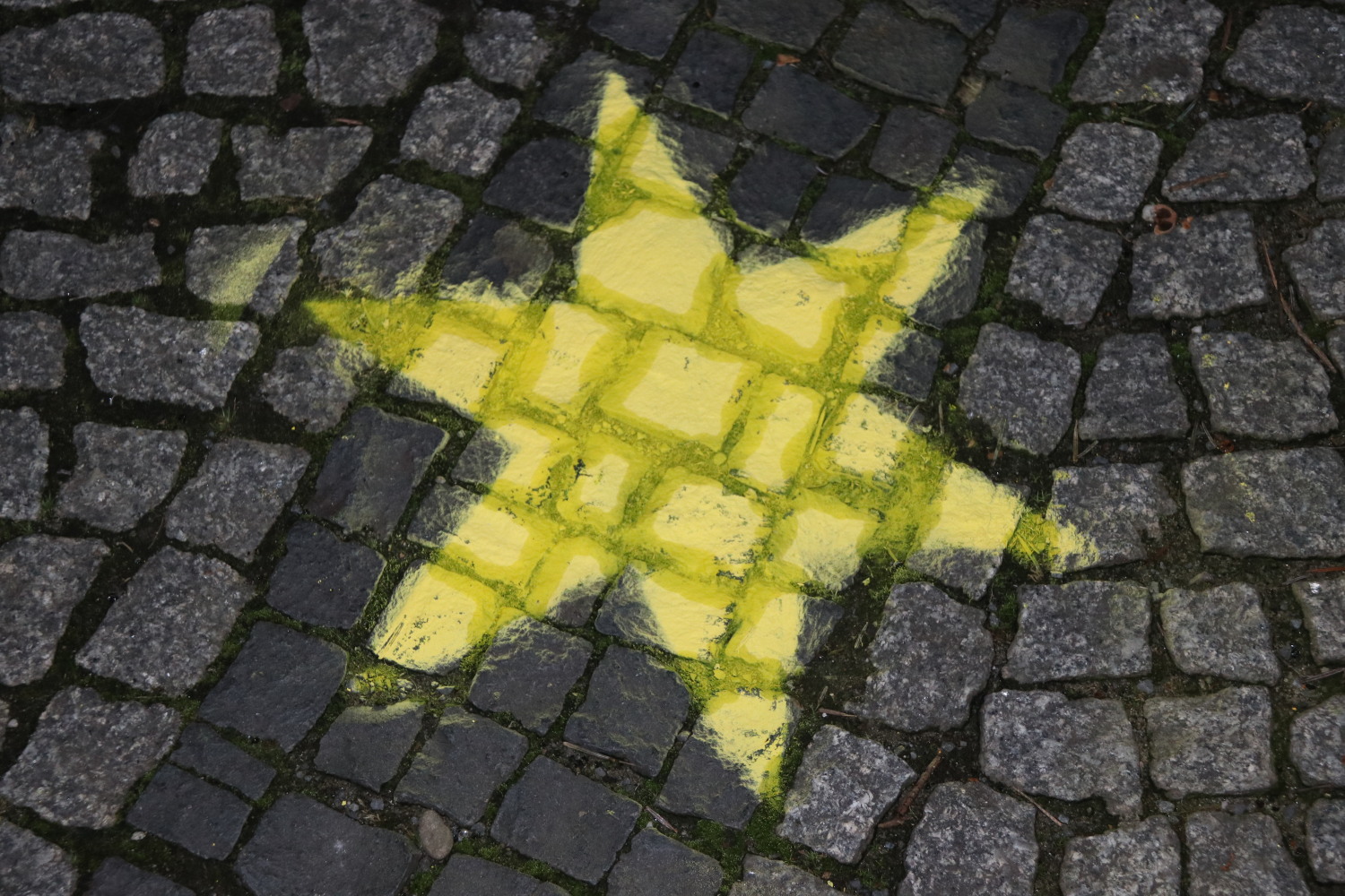 Mit gelber Sprühkreide wurden auf dem Rathausvorplatz gelbe Sterne aufgetragen