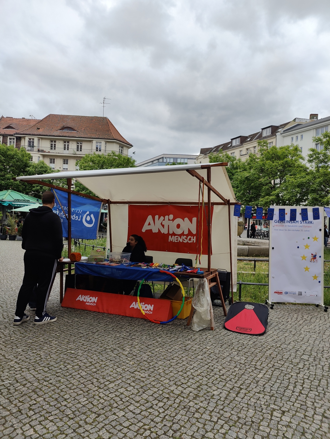 An dem Stand steht ein Wurf-Spiel bereit. Er ist mit dem Logo von Aktion Mensch e.V. geschmückt. Aktion Mensch hat die Veranstaltung mitgefördert.