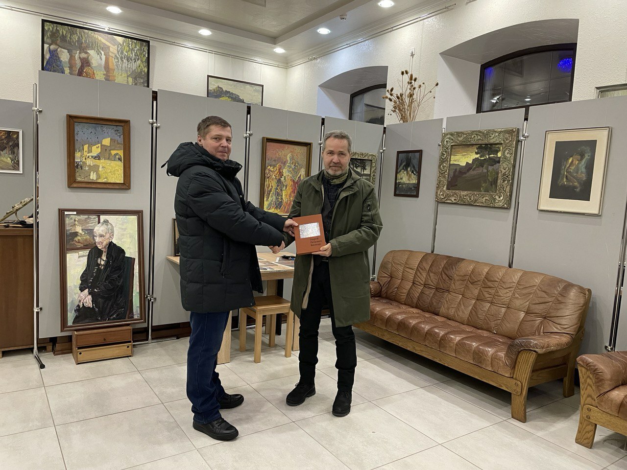 Besuch im Riwne Oblast Museum für Landeskunde: Museumsdirektor Oleksander Bulyha übergibt ein Buch als Geschenk an Sören Benn
