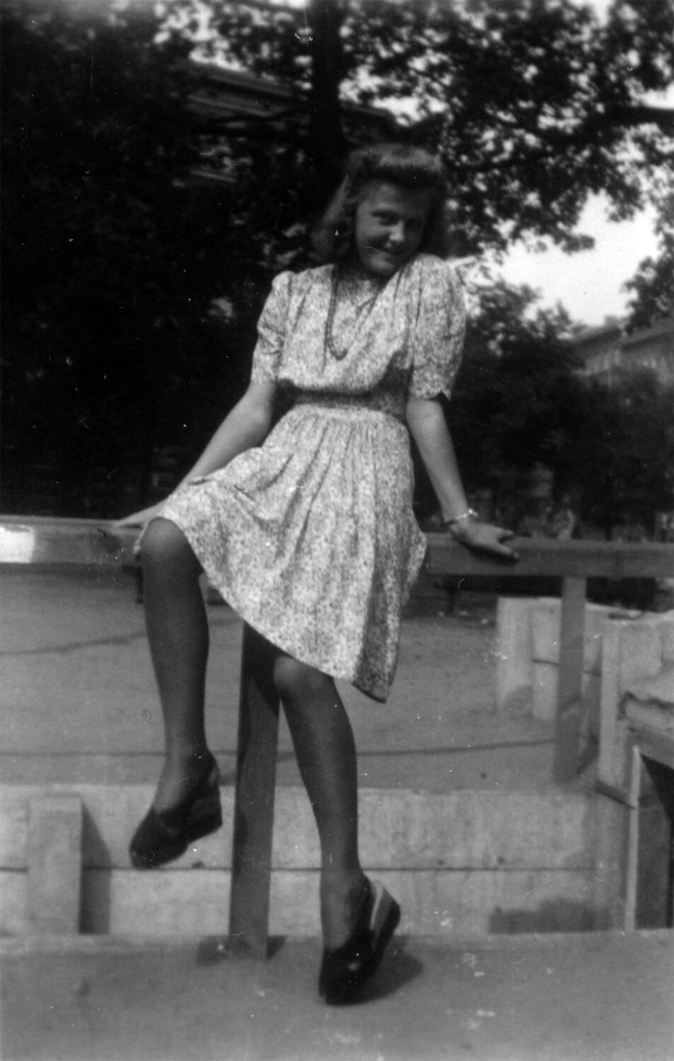 Frau Bögle auf einer Splittergrabenabsperrung auf dem Wörther Platz (Kollwitzplatz) sitzend