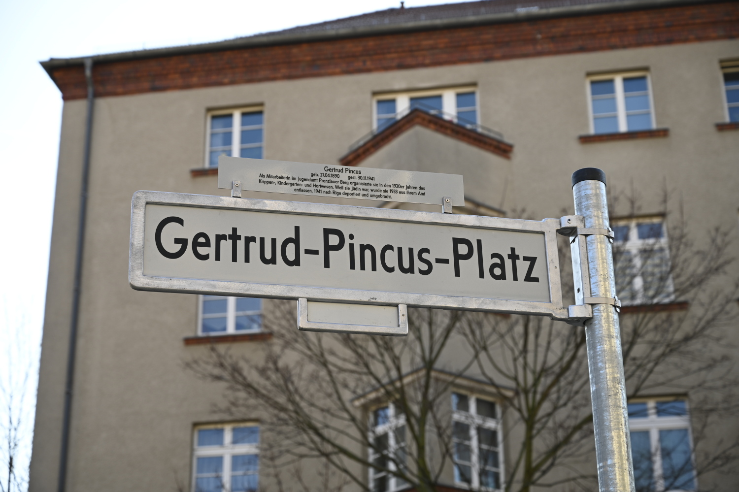 Straßenschild Gertrud-Pincus-Platz, im Hintergrund ein Wohnhaus