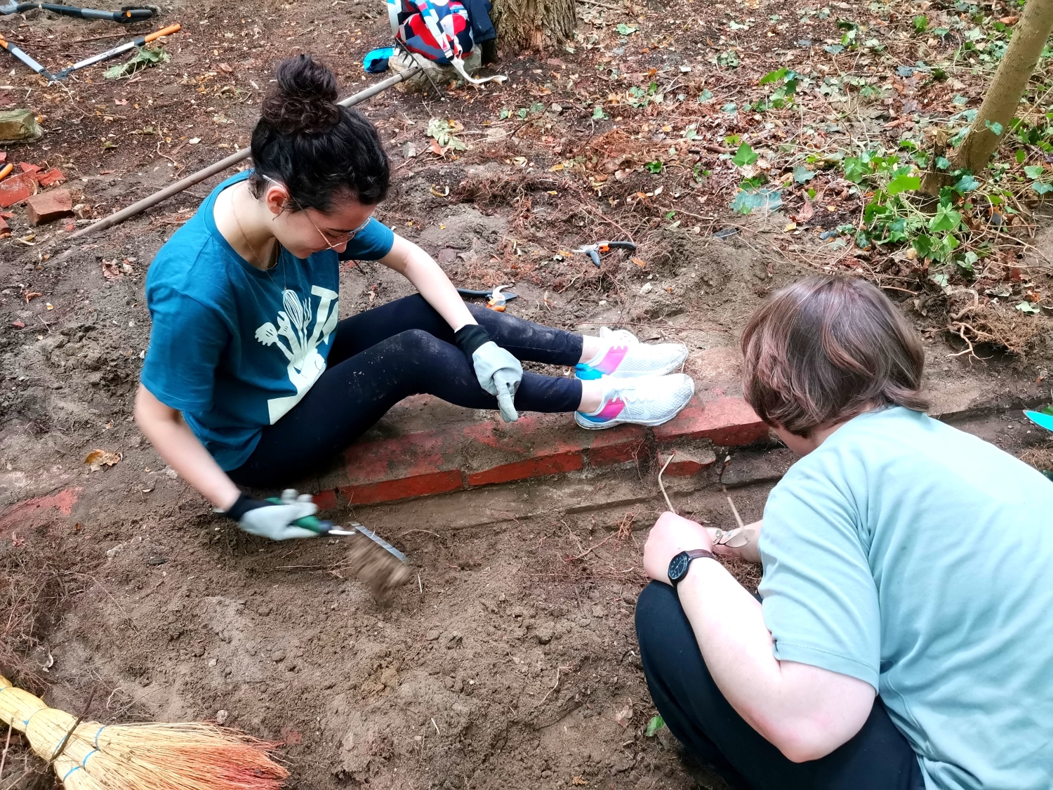 Bodenarbeiten beim Workcamp auf dem Gelände des Alten Anstaltsfriedhofs, Teilnehmerinnen suchen Grabsteinreste