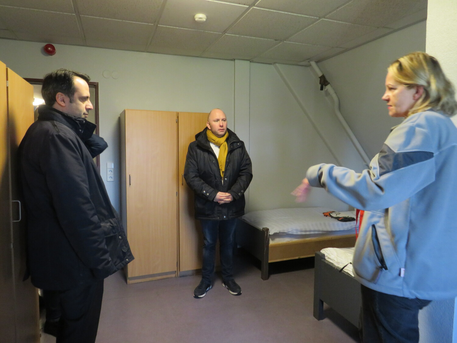 Staatsektretär Boskurt und Bezirksstadtrat Ewers besichtigen Zimmer im Fuchsbau mit Mitarbeitender der Johanniter