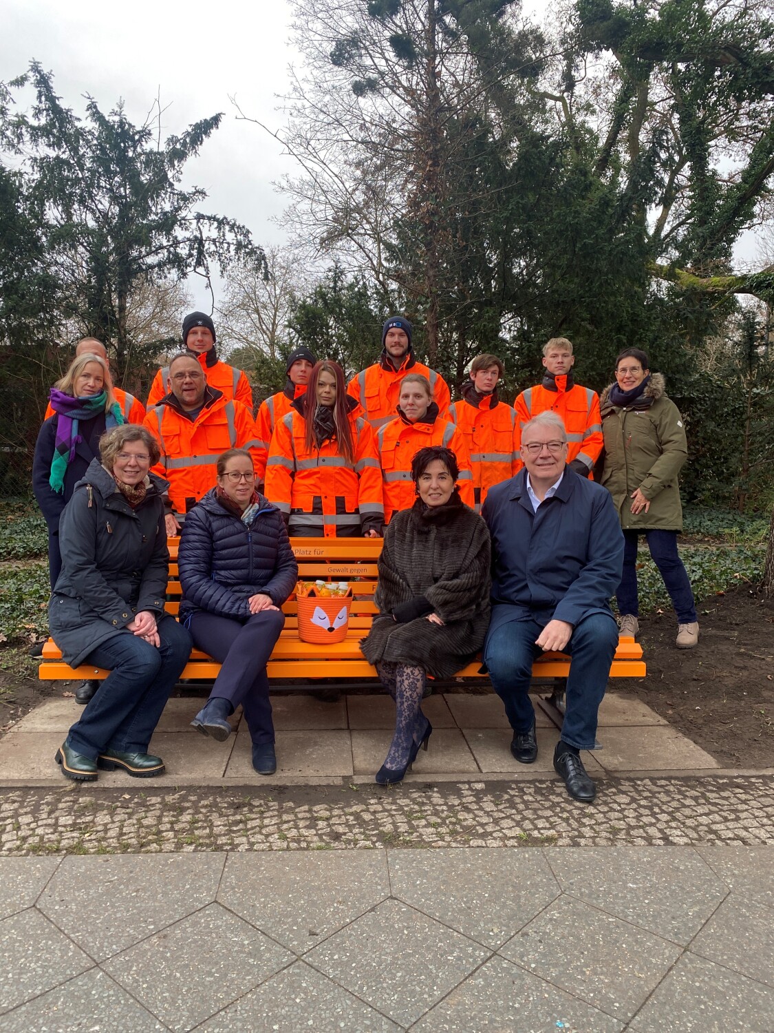 Bezirksamtsmitglieder und Auszubildende des Straßen- und Grünflächenamtes, die die Bank vorbereiteten