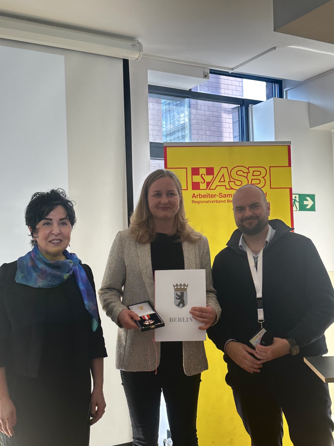 Bezirksbürgermeisterin Emine Demirbüken-Wegner mit Antonia Wieschollek, welche für zehn Jahre aktive Mitarbeit im Katastrophenschutz das Feuerwehr- und Katastrophenschutz-Ehrenzeichen in Silber erhielt, und Daniel Ullrich, scheidender Vorsitzender des ASB-Regionalverbands. Dessen Nachfolge tritt Sven Beutner an.