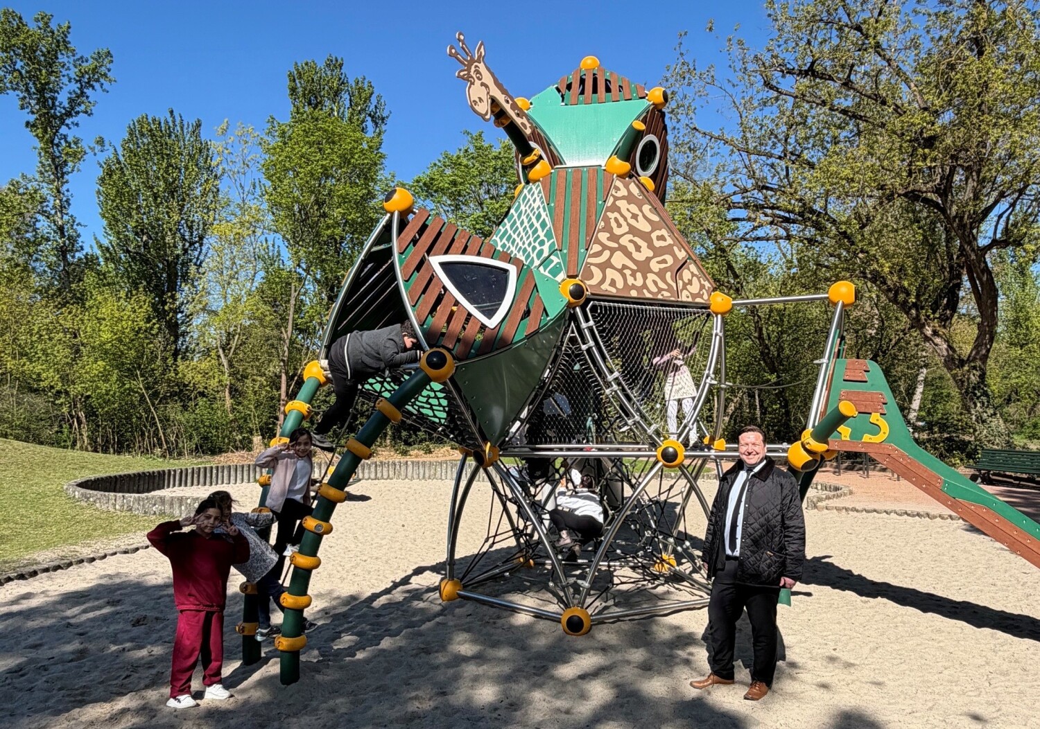 BzStR Pieper gemeinsam mit Kindern, die den neuen Spielplatz spielerisch in Beschlag nehmen