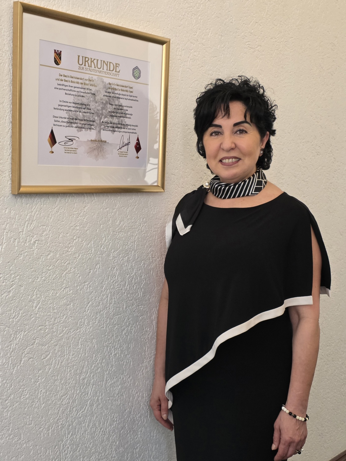 Bezirksbürgermeisterin Demirbüken-Wegner mit der Gründungsurkunde im Rathaus Reinickendorf