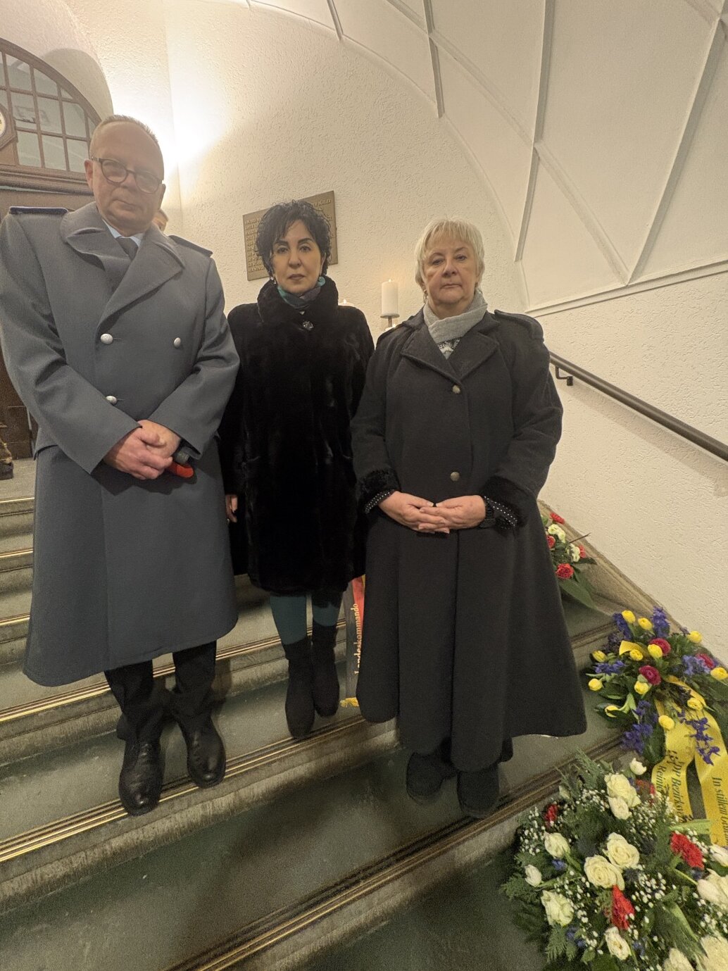 Bezirksverordnetenvorsteherin Kerstin Köppen, Bezirksbürgermeisterin Emine Demirbüken-Wegner und Oberst Jens Roßmanith vor der Erinnerungstafel für die Opfer des Nationalsozialismus.