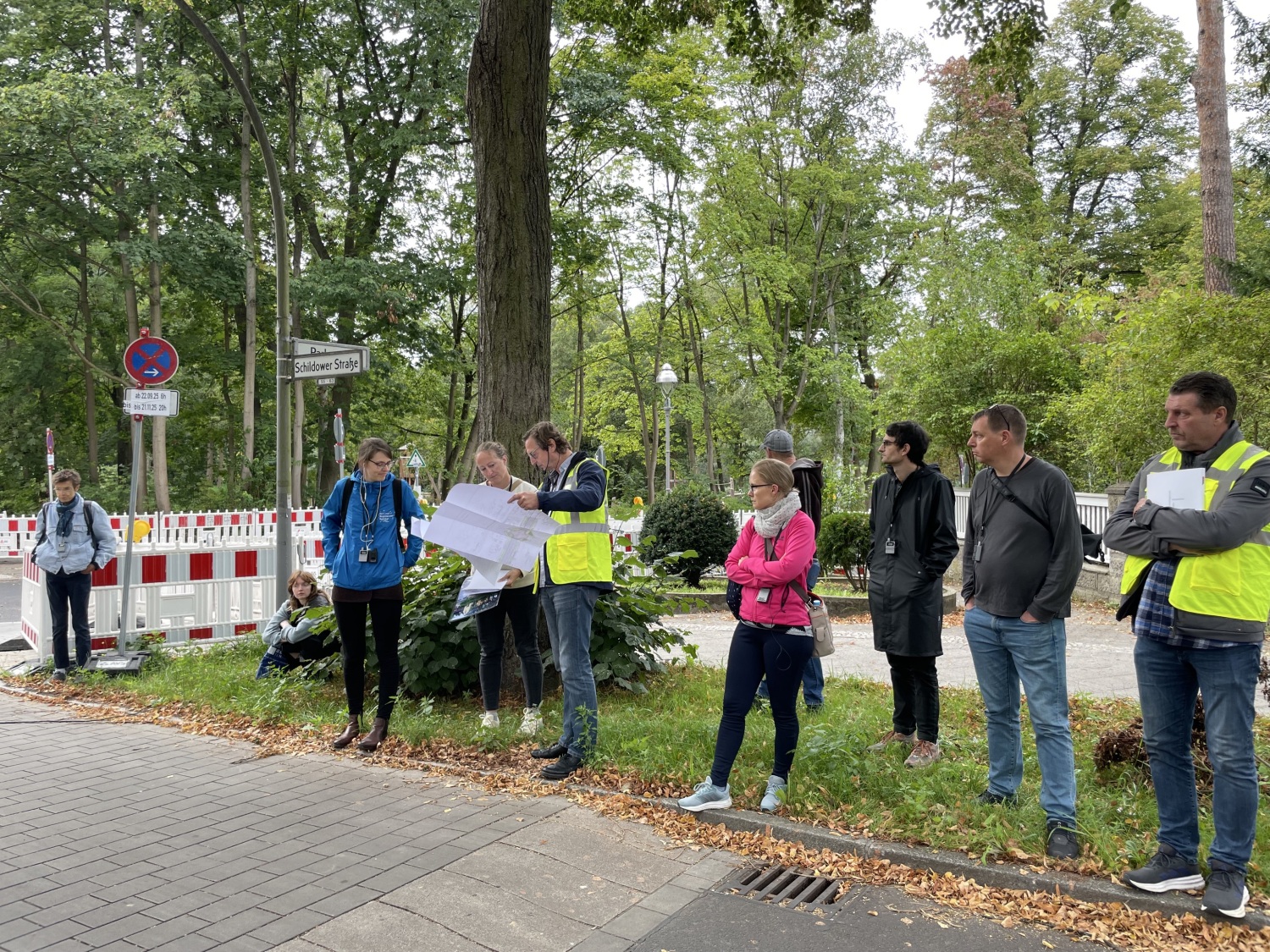 Zur Woche der klimaanpassung 2025 fand auch eine Führung in der Schildower Straße in Reinickendorf statt. Im Rahmen der Sanierungsarbeiten wurden verschiedene Maßnahmen der dezentralen Regenwasserbewirtschaftung umgesetzt: versickerungsfähiges Pflaster, Mulden und Mulden-Rigolen. Hier stehen die Teilnehmenden vor dem versickerungsfähigen Pflaster.
