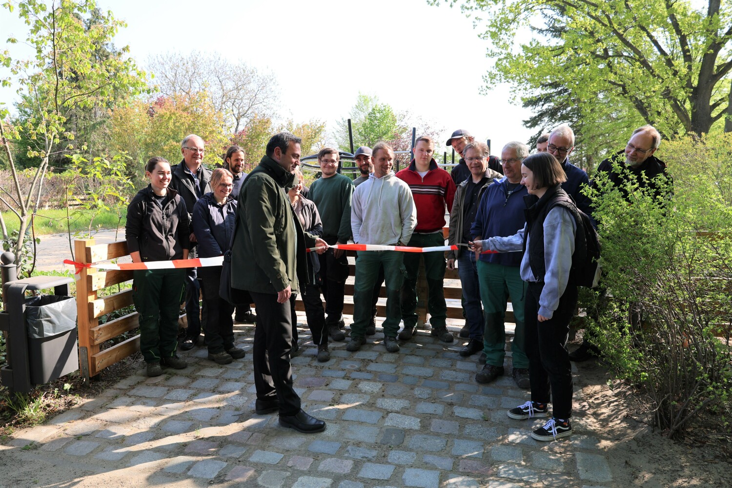 Svenja Jarrath (FB Grünflächen) gemeinsam mit Bezirksstadtrat Urban Aykal und Mitarbeitenden des Fachbereichs bei der offiziellen Eröffnung des sanierten Spielplatzes