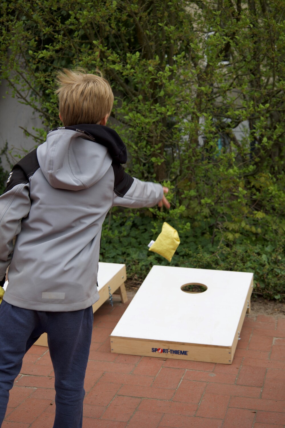Ein Kind beim Cornhole-Spiel (auch bekannt als Bean Bag oder Sackloch)