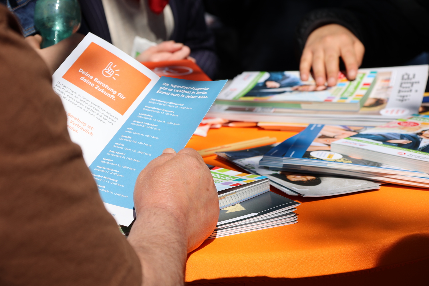 Interessierte Personen stöbern durch die Informationsflyer