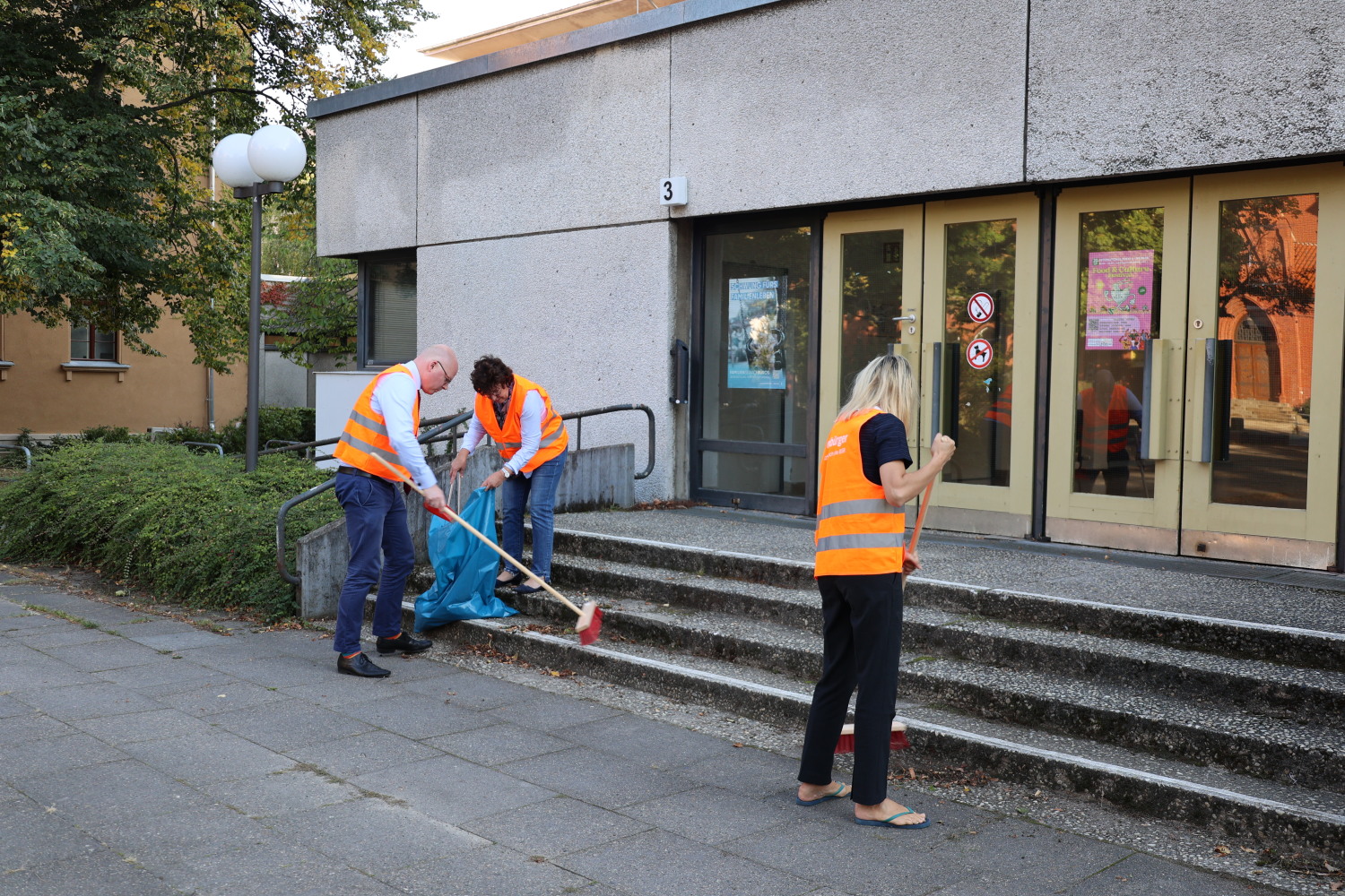 Gemeinsame Putzaktion vor dem Eingang zum Rathaus
