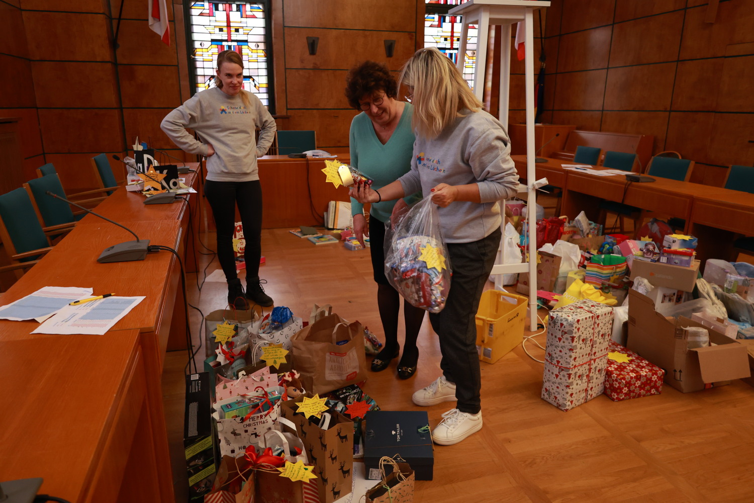Bezirkbürgermeisterin Schellenberg schaut sich mit Mitgliedern des Vereins "Schenk doch mal ein Lächeln e.V." noch mal einige Geschenke der Wunschbaum-Aktion an.