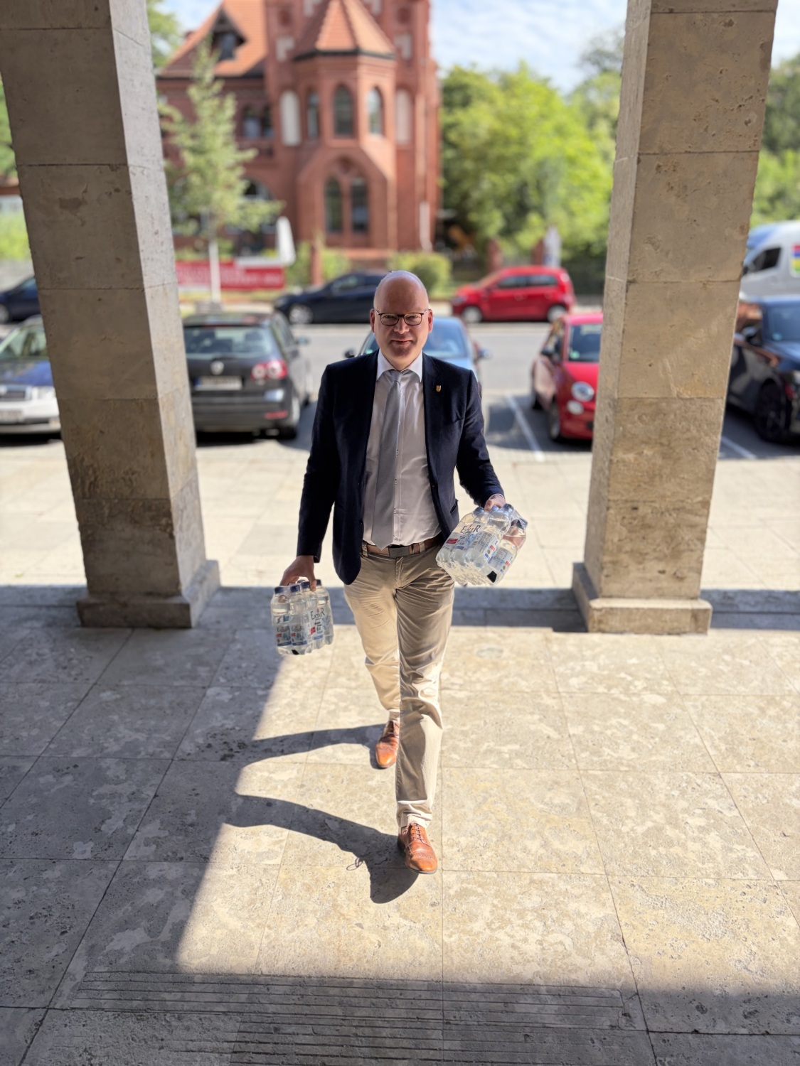 Bezirksstadtrat Tim Richter bringt Wasserflaschen in die Sammelstelle im Rathaus Zehlendorf