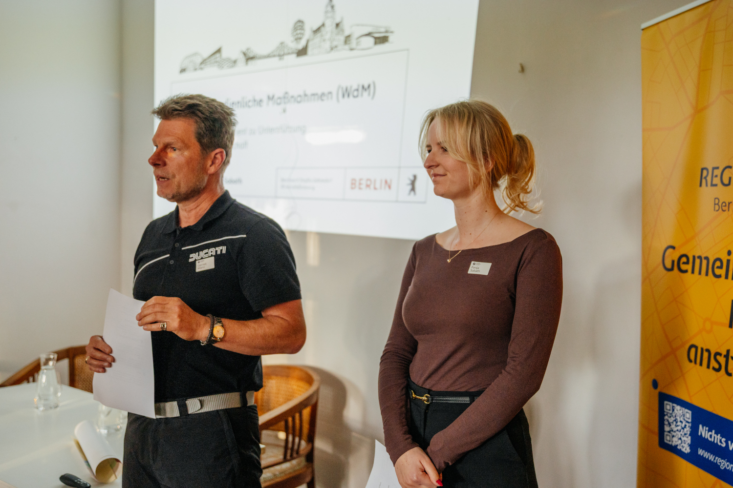 (v.l.n.r.): Gernot Mann und Fenja Sabath (Wirtschaftsförderung Bezirksamt Steglitz-Zehlendorf) während ihres Vortrags vor den Gästen des 34. RegioTalks