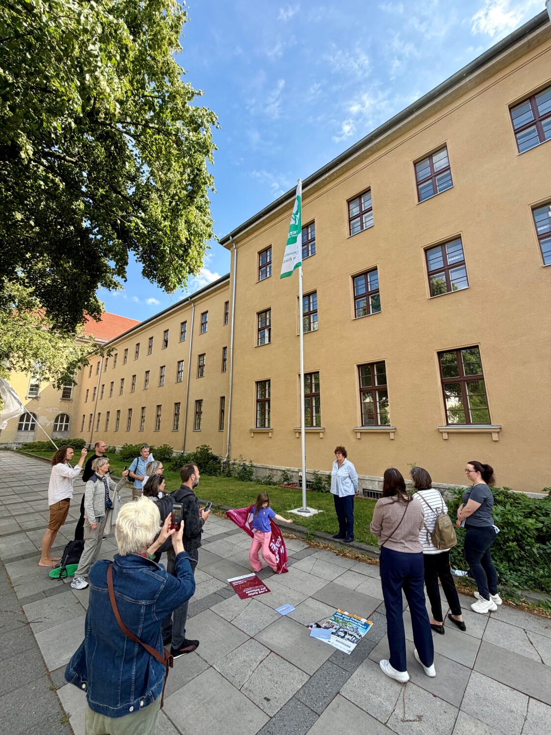 Bezirksbürgermeisterin Frau Schellenberg und Bürgerinnen und Bürger zur Hissung der Flagge "Mayor for Peace"