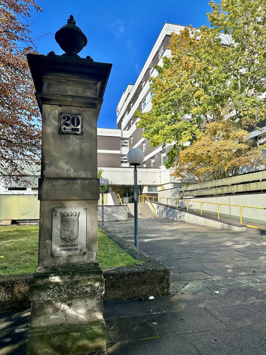 Säule mit Schriftzug „Finanzamt Zehlendorf“ vor dem Haupteingang