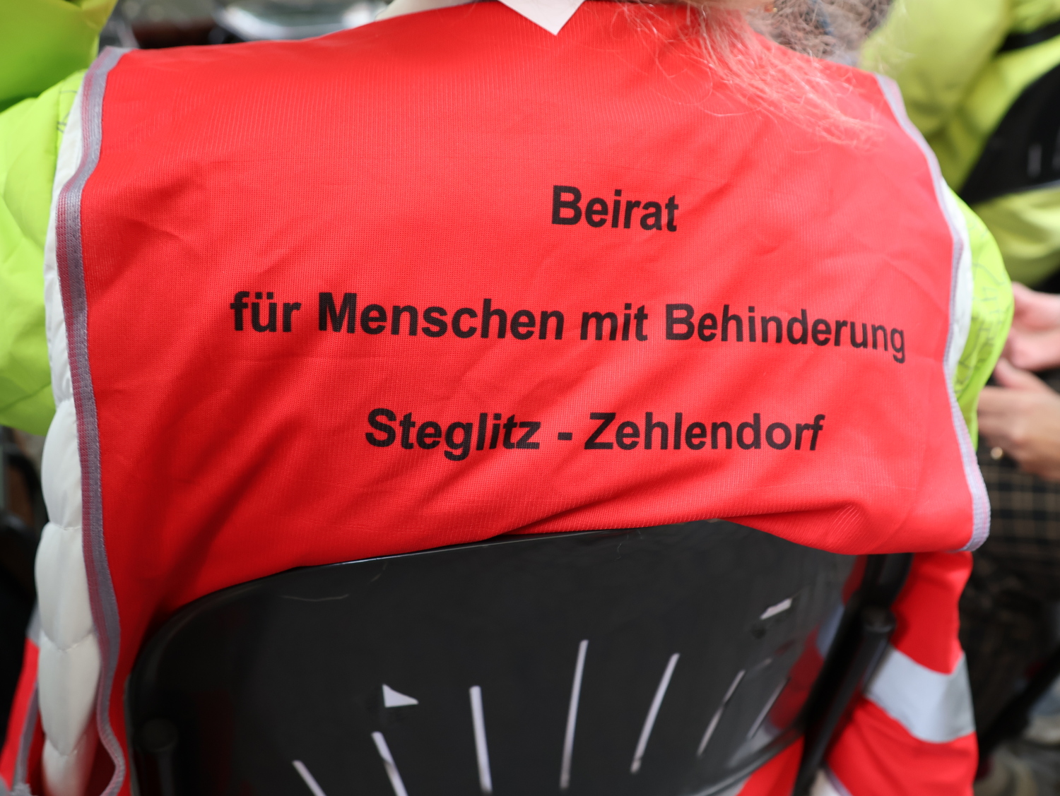 Aktionstag Bunt Verbindet 2026 - Der Beirat für Menschen mit Behinderungen war auch vor Ort. Es ist eine rote Weste mit schwarzer Schrift "Beirat für Menschen mit Behinderung Steglitz-Zehlendorf" abgebildet.