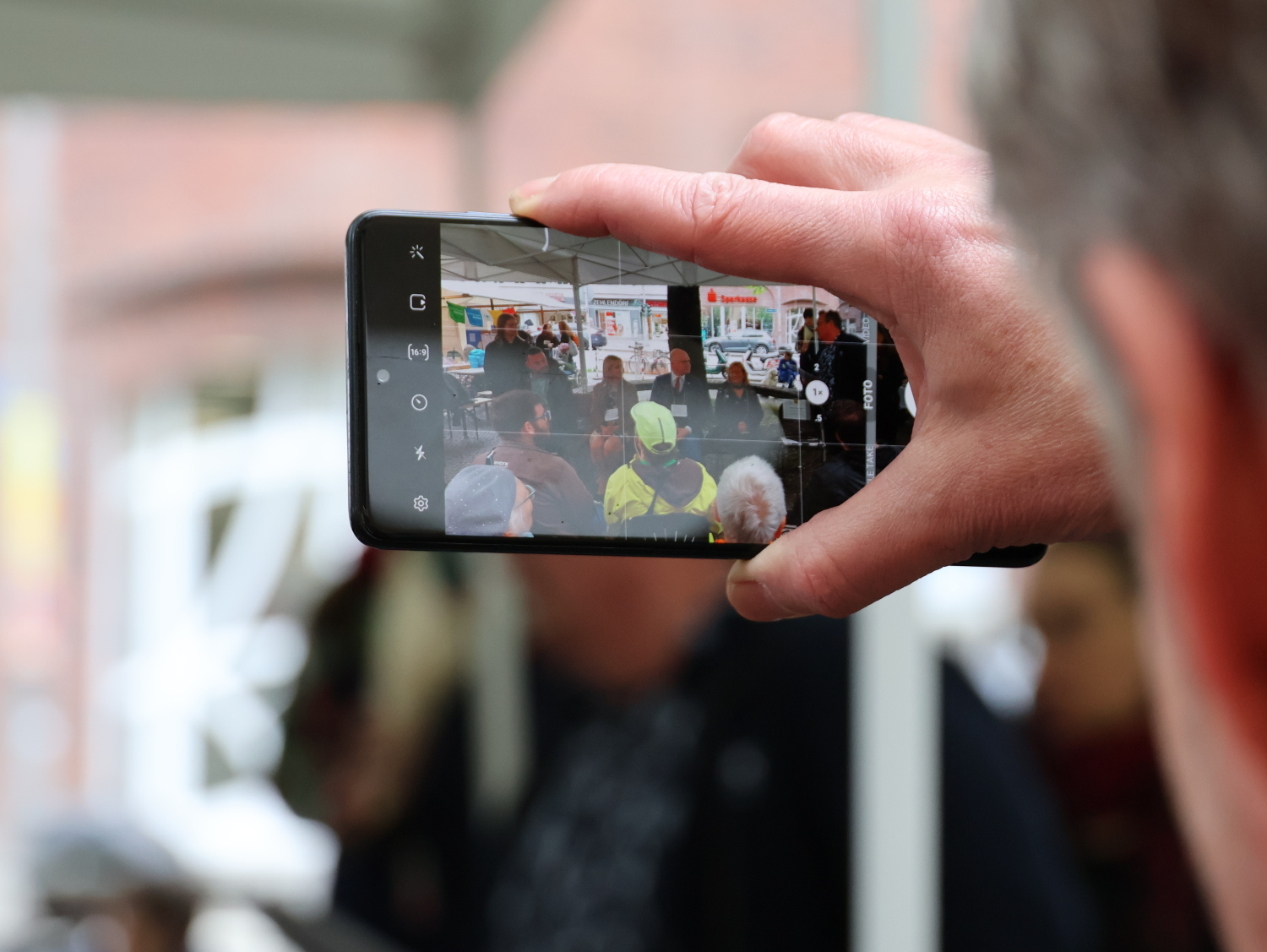 Politik-Talk "Mitreden! Inklusion im Bezirk" - Es wurde fotografiert, das Display eines Smartphones fotografiert, das gerade ein Foto der Talkrunde macht.