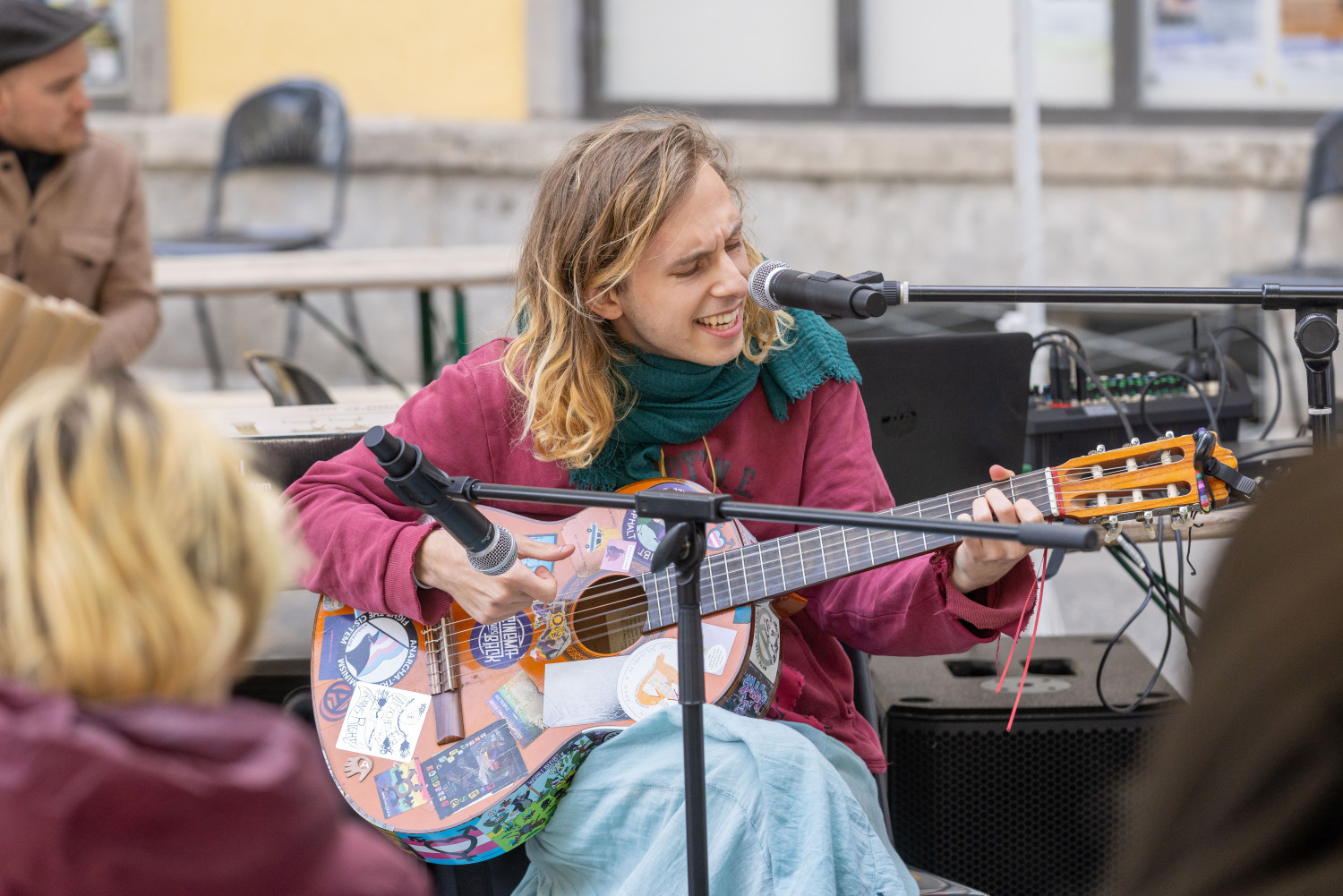 Musiker*in Ponyo Elfenpunk spielt Gitarre und singt und lacht.