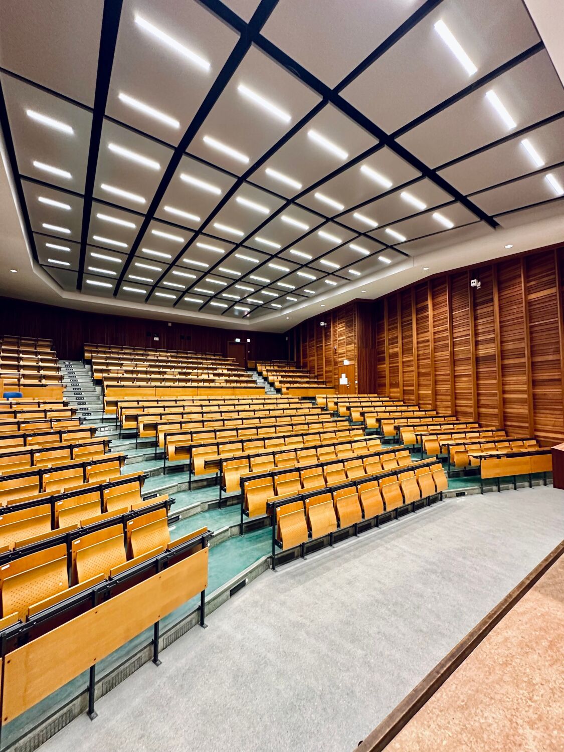 Blick aus Richtung links der Tafel quer über die Sitzbänke des Audimax